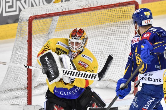 Der Berner Goalie Tomi Karhunen, links, schnappt den Puck vor dem Davoser Marc Aeschlimann, im ersten Eishockey-Pre-Playoff Qualifikationsspiel der National League zwischen dem HC Davos und dem SC Ber ...