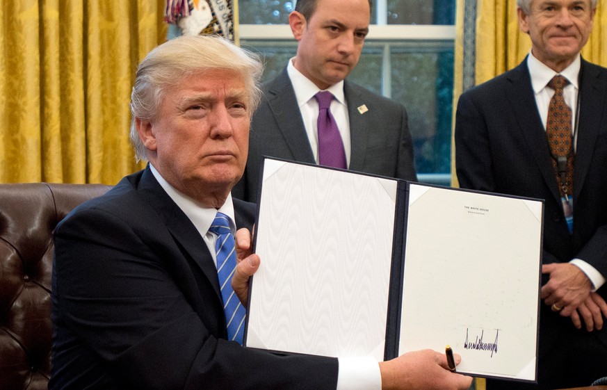 epa05744777 US President Donald J. Trump shows the Executive Order withdrawing the US from the Trans-Pacific Partnership (TPP) after signing it in the Oval Office of the White House in Washington, DC, ...