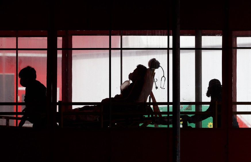 epa08362590 Paramedics bring a patient into the emergency room at Elmhurst Hospital Center in Queens, New York, USA, on 14 April 2020. The number of confirmed COVID-19 patients continues to rise in th ...