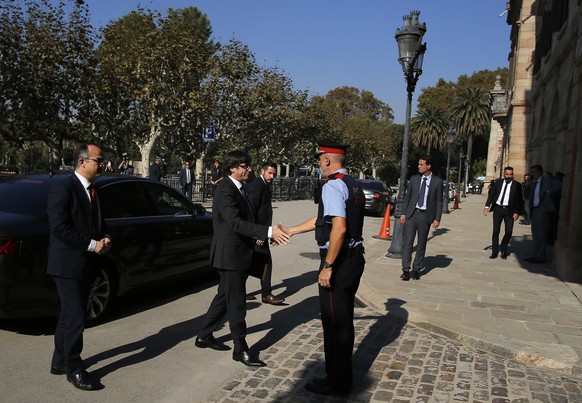 Catalan President Carles Puigdemont, second left, is greeted as he arrives at the Catalan parliament in Barcelona, Spain, Friday, Oct. 27, 2017. Catalonia&#039;s parliament on Friday will resume debat ...