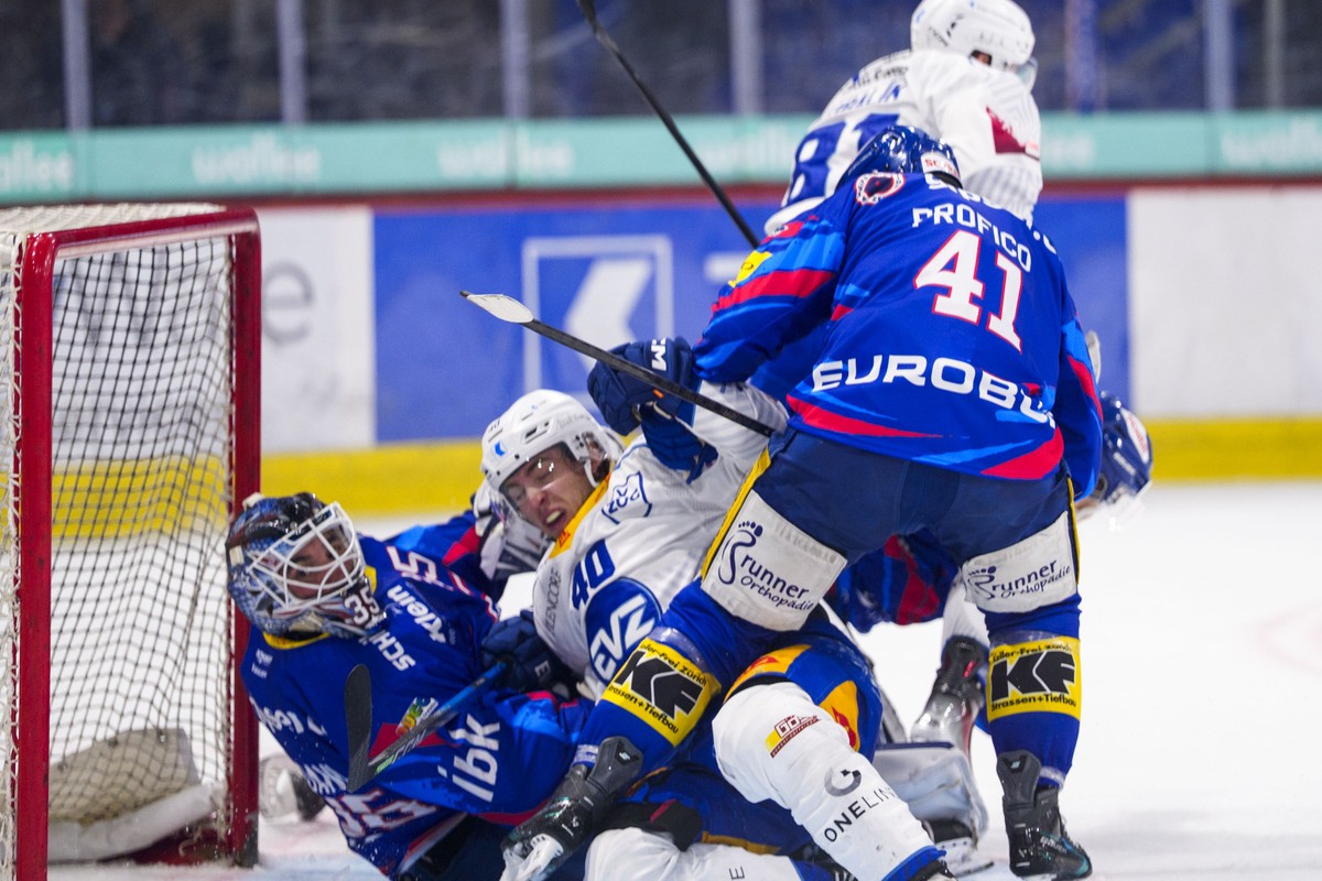EV Zug Stuermer Andreas Wingerli (#40) gegen EHC Kloten Torhueter Davide Fadani und Verteidiger Leandro Profico (#41) waehrend dem Qualifikationsspiel der Eishockey-Meisterschaft der National League z ...