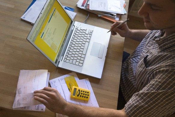 A man pays his bills via Postfinance&#039;s online portal in his flat in Winterthur in the canton of Zurich, Switzerland, pictured on February 5, 2009. (KEYSTONE/Alessandro Della Bella) 

Ein Mann bez ...