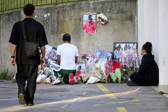 KEYPIX - Des personnes se recueillent devant des fleurs qui sont deposees sur le lieu de l&#039;accident mortel au lendemain de la deuxieme nuit d&#039;emeutes suite a l&#039;accident mortel survenu a ...