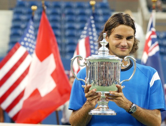 Roger Federer, of Switzerland, poses with the championship trophy after defeating Lleyton Hewitt, of Australia, in the men's singles final at the U.S. Open tennis tournament in New York, Sunday, ...