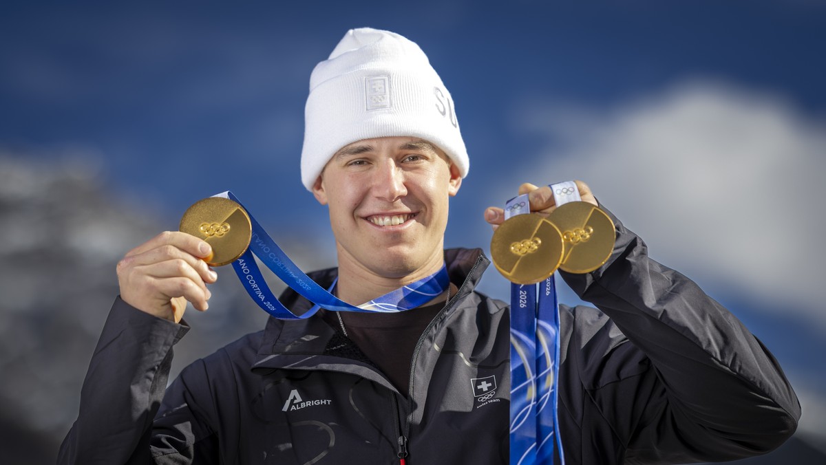 Gold medalist Franjo von Allmen of Switzerland poses for photographers with his three gold medals during a photocall outside the Swiss team hotel at the 2026 Olympic Winter Games at the Stelvio Ski ce ...
