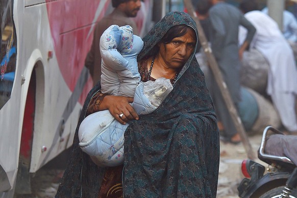 epa10949304 An Afghani woman walks as refugees prepare to voluntarily depart for their homeland, in Karachi, Pakistan, 30 October 2023. Pakistan&#039;s government ordered earlier this month all immigr ...