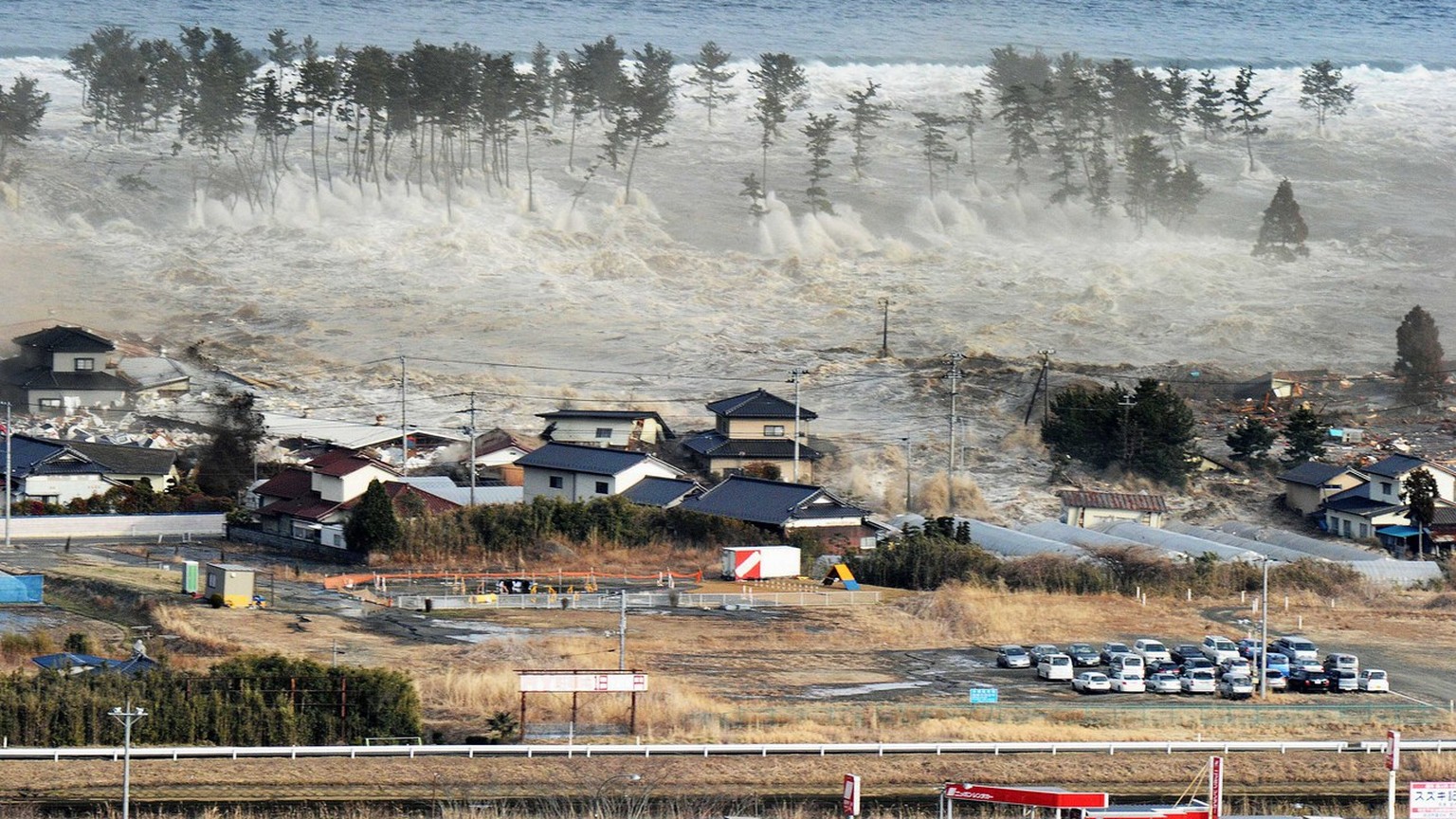 FILE -In this March 11, 2011 file photo, waves of a tsunami hit residences after a powerful earthquake in Natori, Miyagi prefecture (state), Japan. A government-commissioned panel of experts said Satu ...