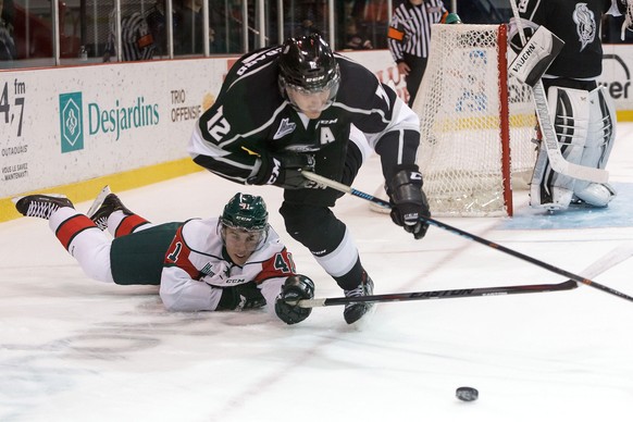 GATINEAU, CANADA - OCTOBER 24: Mickael Beauregard #12 of the Gatineau Olympiques trips as he battles for a loos puck against Maxime Fortier #41 of the Halifax Mooseheads on October 24, 2014 at Robert  ...