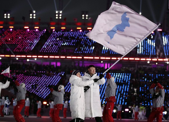 North Korea's Hwang Chung Gum and South Korea's Won Yun-jong carries the flag during the opening ceremony of the 2018 Winter Olympics in Pyeongchang, South Korea, Friday, Feb. 9, 2018. (AP Photo/Jae C. Hong)