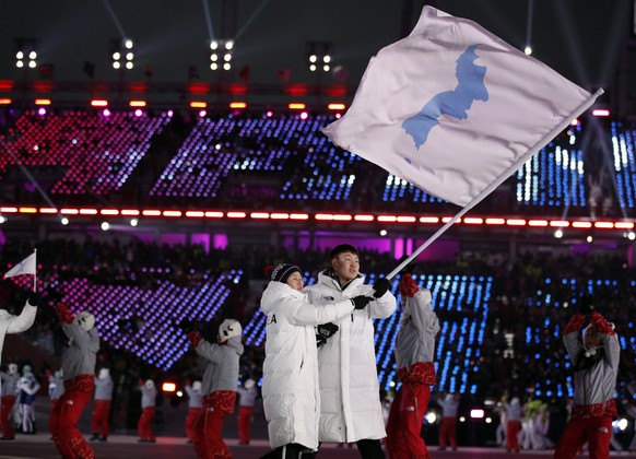 North Korea&#039;s Hwang Chung Gum and South Korea&#039;s Won Yun-jong carries the flag during the opening ceremony of the 2018 Winter Olympics in Pyeongchang, South Korea, Friday, Feb. 9, 2018. (AP P ...