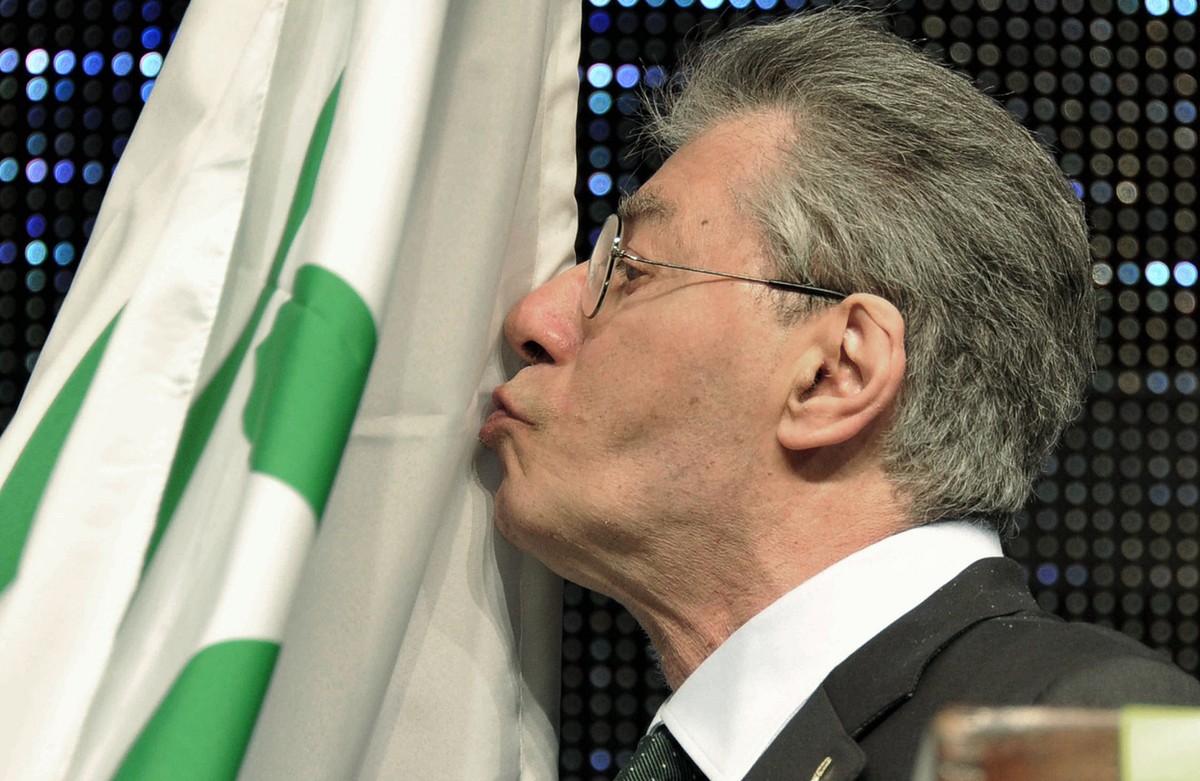 Former Northern League party leader and founder Umberto Bossi, kisses his party flag during a party rally in Bergamo, northern Italy, Tuesday, April 10, 2012. Bossi, whose support kept Silvio Berlusco ...