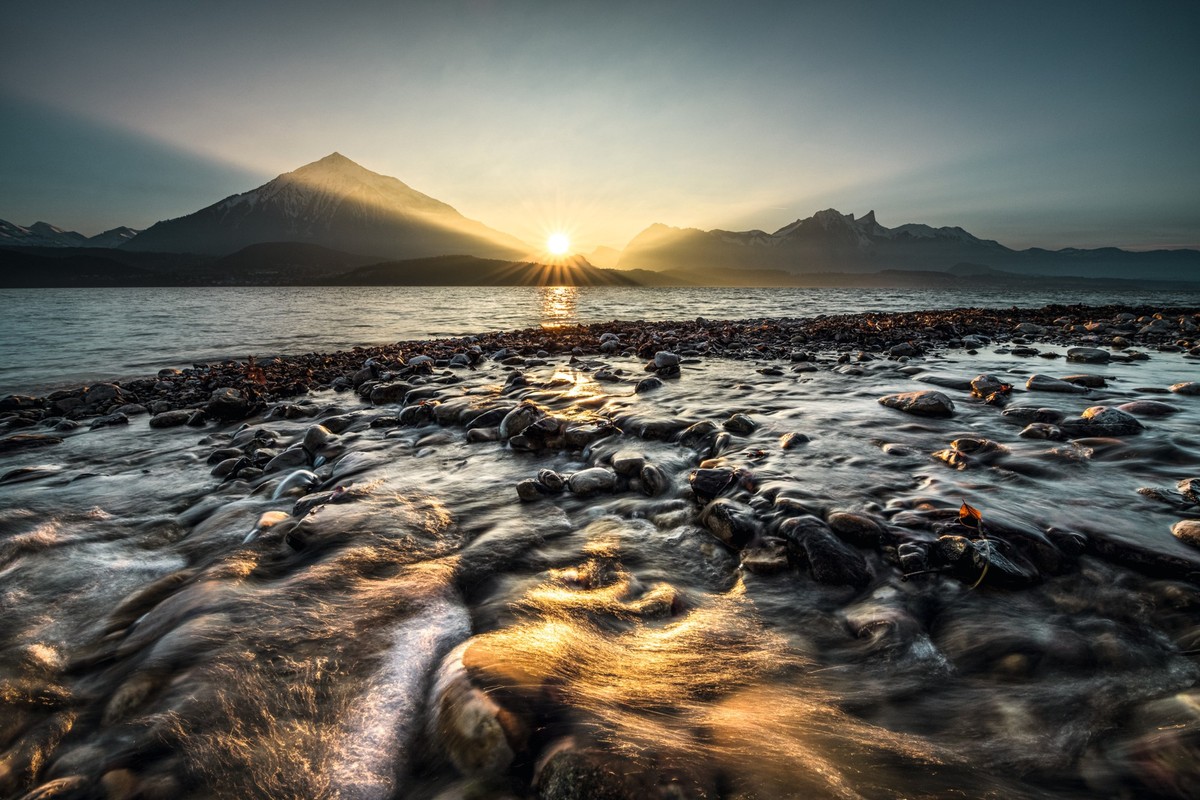 Blick ueber den Thunersee mit Niesen und Sonnenuntergang im Hintergrund.View over Lake Thun with Niesen and sunset in the background.