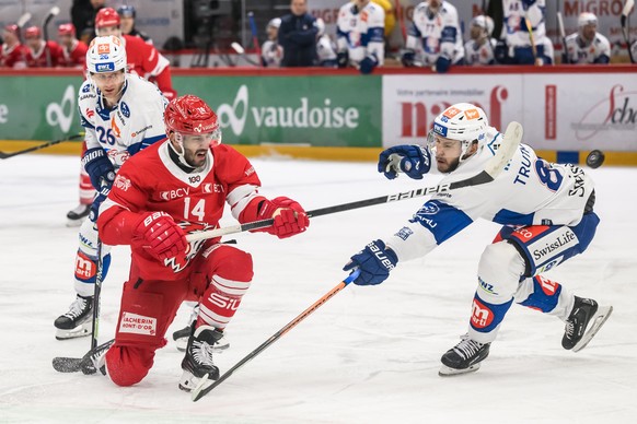 L&#039;attaquant lausannois Jason Fuchs, gauche, lutte pour le puck avec le defenseur des ZSC Dario Trutmann, droite, lors du match du championnat suisse de hockey sur glace de National League entre L ...