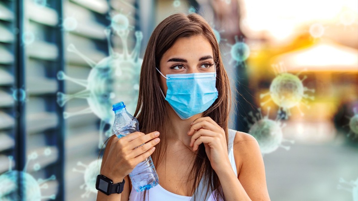 COVID-19 Pandemic Coronavirus Woman in city street wearing protective face mask for spreading of disease virus SARS-CoV-2. Girl with protective mask on face against Coronavirus Disease 2019.