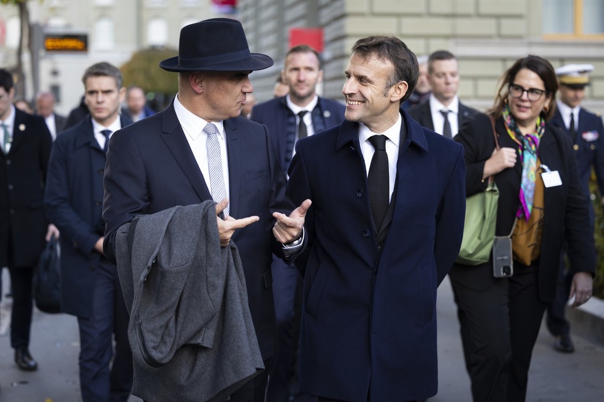 Swiss Federal President Alain Berset, left, and French President Emanuel Macron discuss on their way to the delegation meeting in front of the Federal Palace, the Swiss Parliament building, in Bern, S ...
