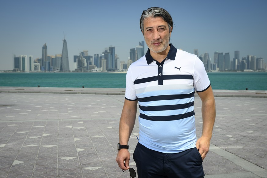 epa09865131 Switzerland&#039;s soccer national team head coach Murat Yakin poses in front of flags from countries qualified next to the countdown clock the day after the draw for the 2022 FIFA World C ...