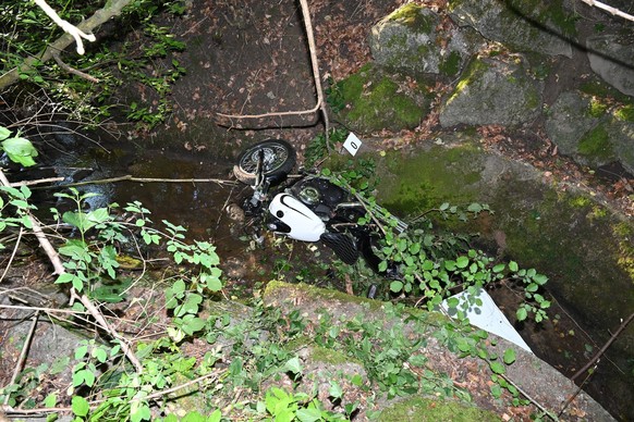 Ein weisses Motorrad liegt in einem Bach Unfall Ottikon