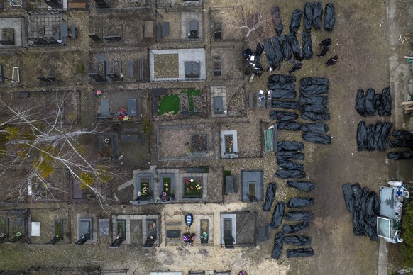 Policemen work to identify civilians who were killed during the Russian occupation in Bucha, Ukraine, on the outskirts of Kyiv, before sending the bodies to the morgue, Wednesday, April 6, 2022. (AP P ...