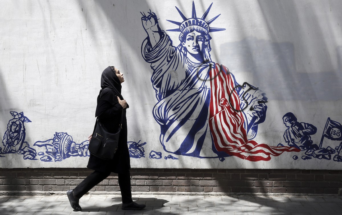 epa10686665 An Iranian woman, wearing a veil, walks next to an anti-US mural in a street in Tehran, Iran, 12 June 2023. Iran's Supreme Leader Ali Khamenei said on 11 June during a meeting with Ir ...