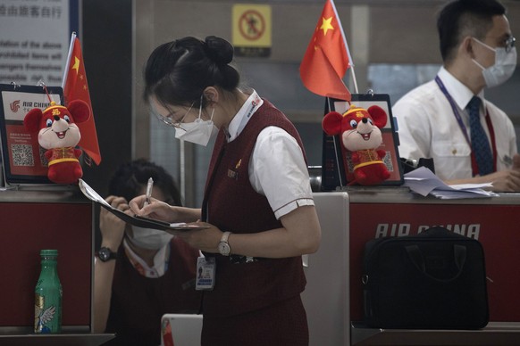 Airline employees work at a check-in counter at the Beijing Capital Airport terminal 3 in Beijing on Wednesday, June 17, 2020. The Chinese capital on Wednesday canceled more than 60% of commercial fli ...