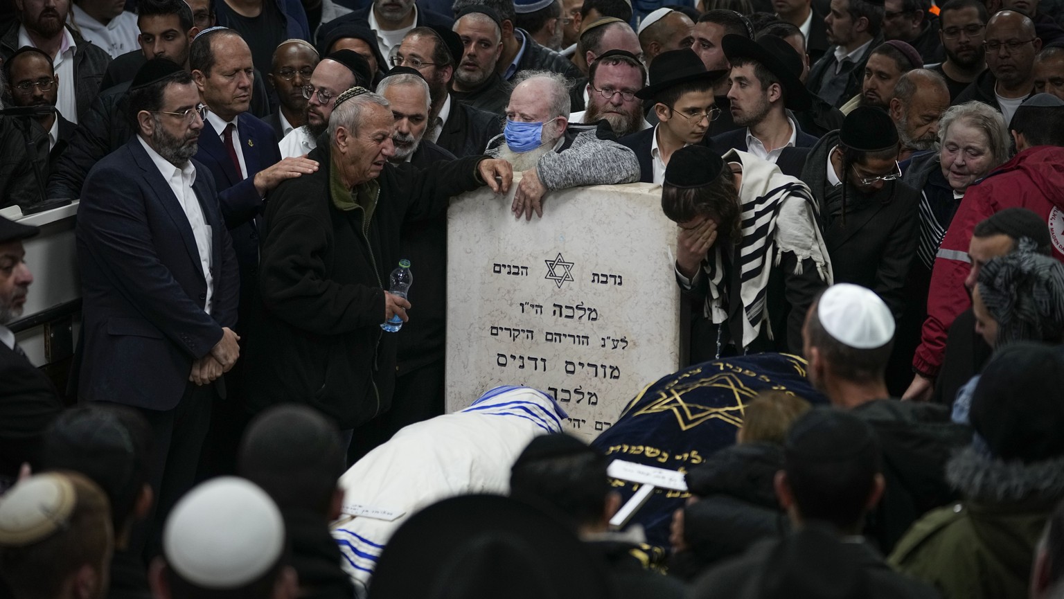 Mourners attend the funeral of Israeli couple Eli Mizrahi and his wife, Natalie, victims of a shooting attack Friday in east Jerusalem, at the cemetery in Beit Shemesh, Israel, early Sunday, Jan. 29,  ...