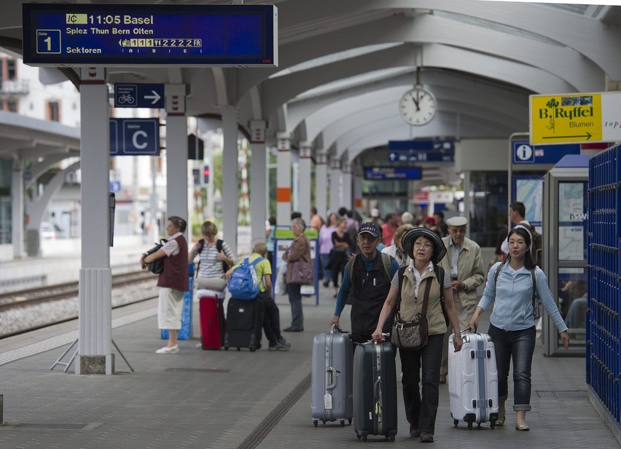 Asiatische Touristen warten auf den Zug, am Samstag 6. August 2011, in Interlaken West. Der starke Schweizer Franken macht der Tourismusbranche Sorgen und haelt die Touristen fern. (KEYSTONE/Peter Sch ...