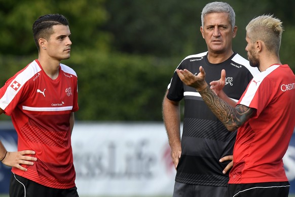 epa05515769 Swiss soccer players Granit Xhaka, left, and Valon Behrami, right, and Swiss coach Vladimir Petkovic, center, are pictured during a training session, Tuesday, 30 August 2016, in Freienbach ...