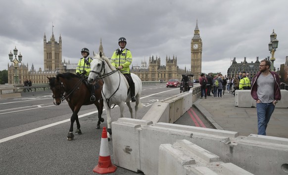 Mounted police ride by newly installed barriers on Westminster Bridge in London, Monday, June 5, 2017. Police arrested several people and are widening their investigation after a series of attacks des ...