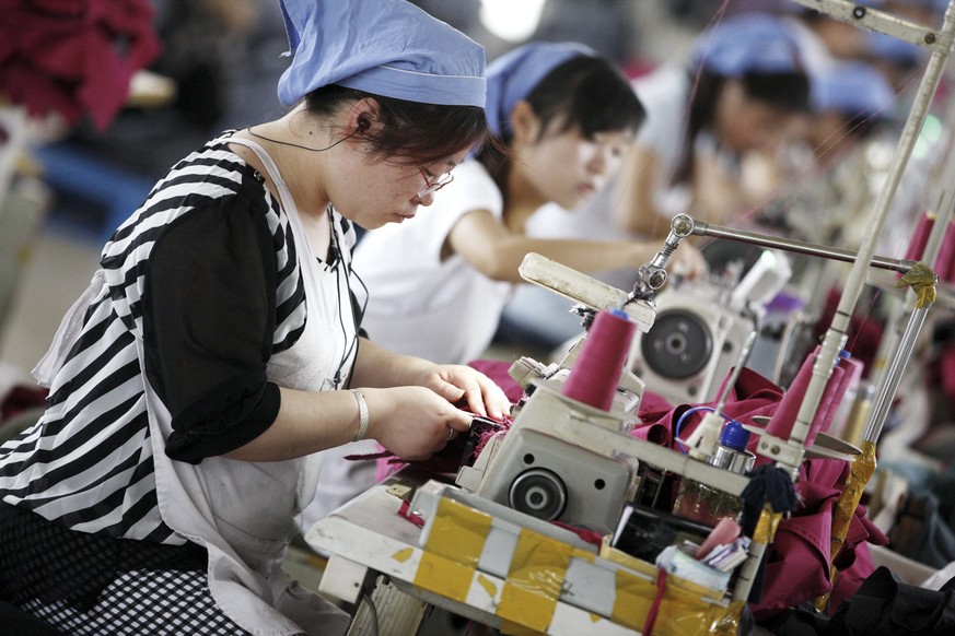 epa04778563 Female workers make clothes for export to Germany at a clothing factory in Huaibei, Anhui province, east China, 01 June 2015. China&#039;s official purchasing managers&#039; index (PMI) ro ...