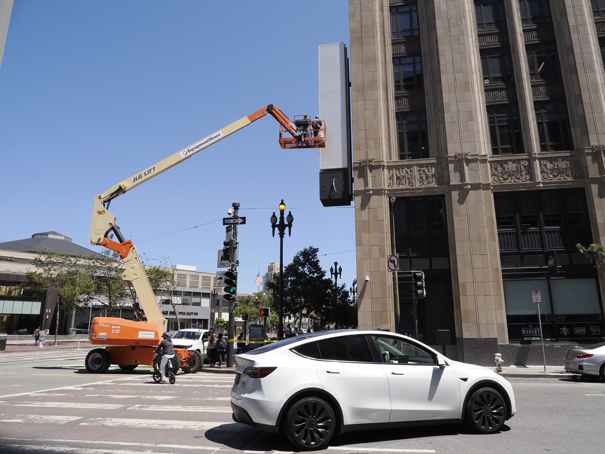epa10779045 Workers move closer to clean the vertical Twitter sign after all signage pertaining to Twitter was removed after the owner of the company, Elon Musk, annouced the rebranding of the social  ...