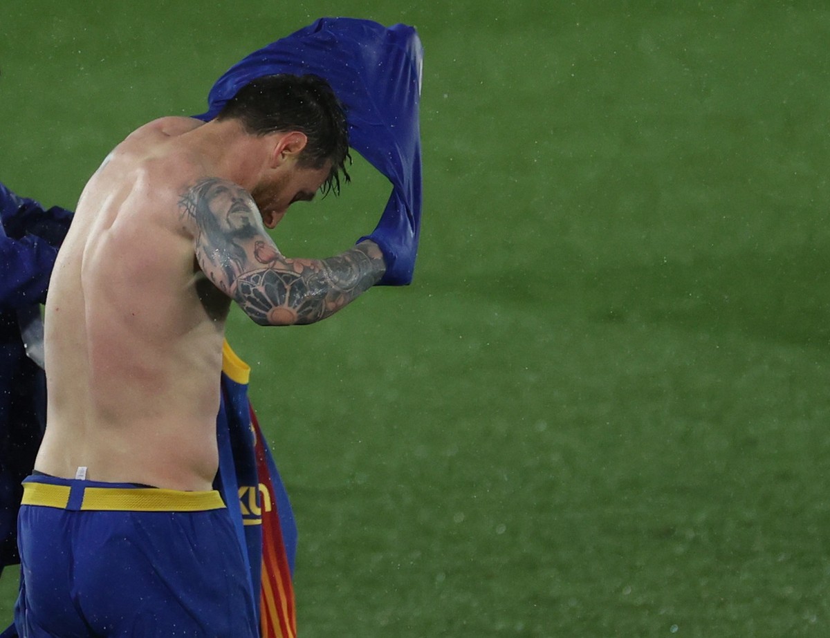 epa09127876 FC Barcelona's Leo Messi changes his jersey during the Spanish LaLiga soccer match between Real Madrid and FC Barcelona at Alfredo di Stefano stadium in Madrid, Spain, 10 April 2021.  ...