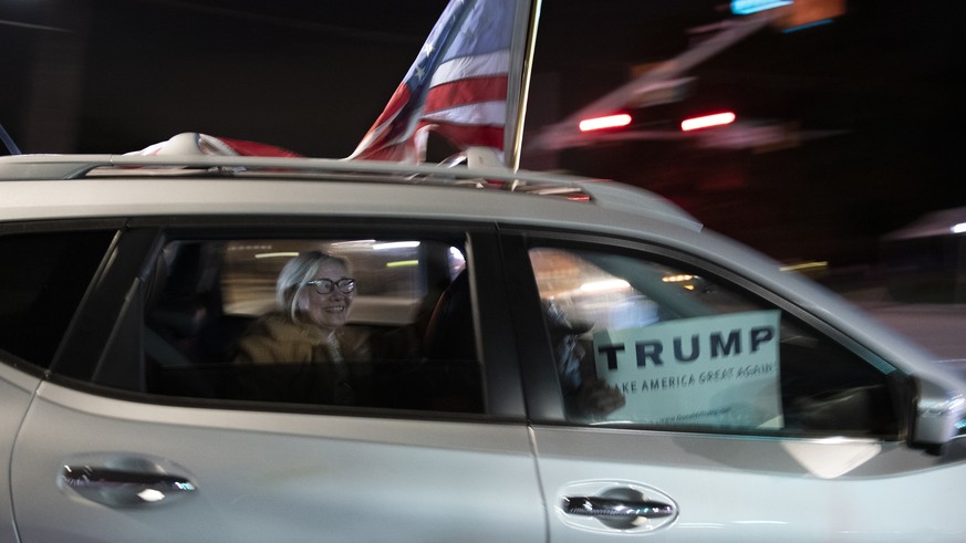 Supporters of President Donald Trump drive past the entrance to Walter Reed National Military Medical Center in Bethesda, Md., Sunday, Oct. 4, 2020. Trump went to the hospital Friday after testing pos ...