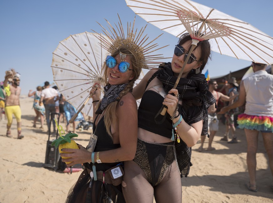 epa06740001 Rachel (R) and a friend, two &#039;burners&#039; in the Israeli MidBurn festival, near Sde Boqer in the Negev Desert in southern Israel, 15 May 2018. The festival is drawing thousands of & ...