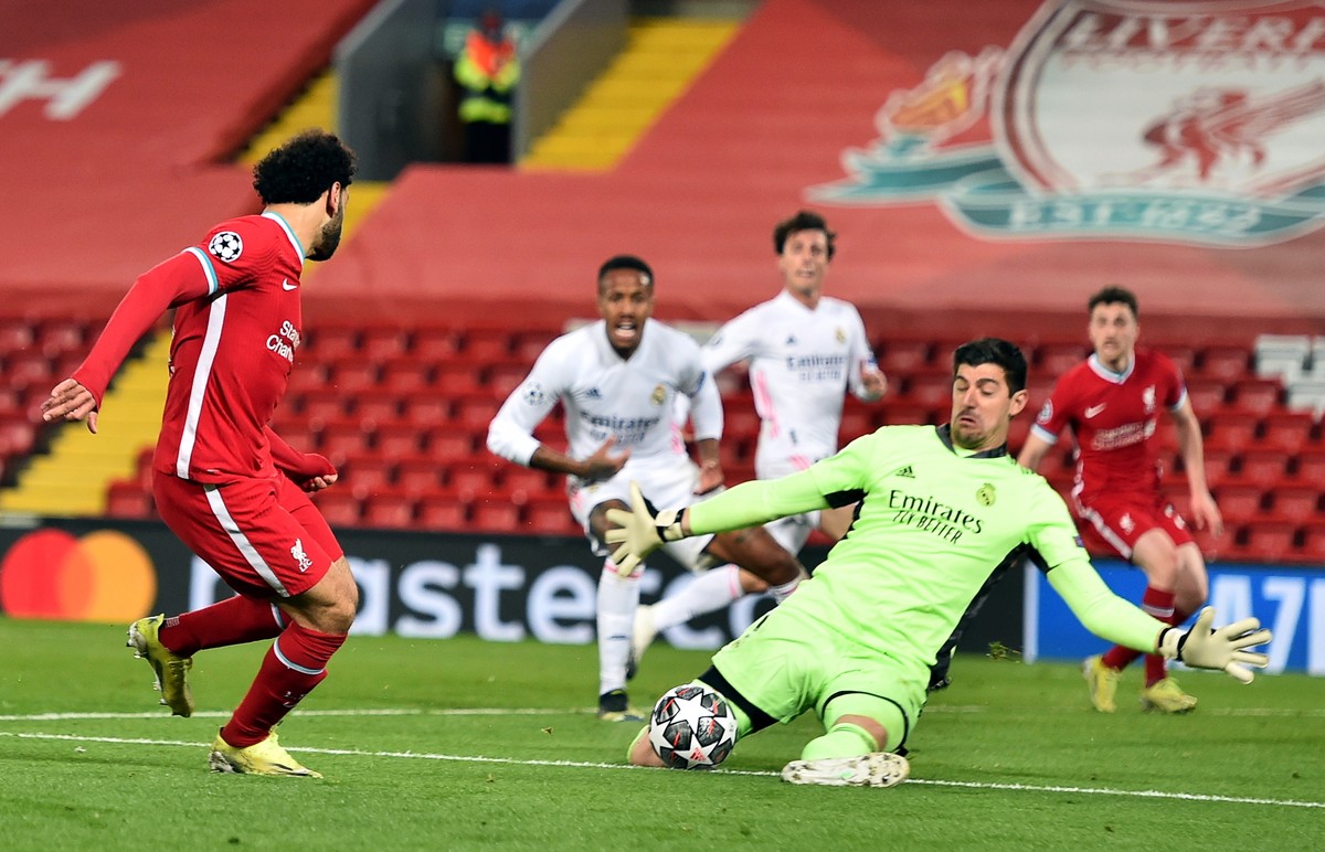 epa09135918 Liverpool's Mohamed Salah (L) in action against Real Madrid's goalkeeper Thibaut Courtois (R) during the UEFA Champions League quarter final, second leg soccer match between Live ...