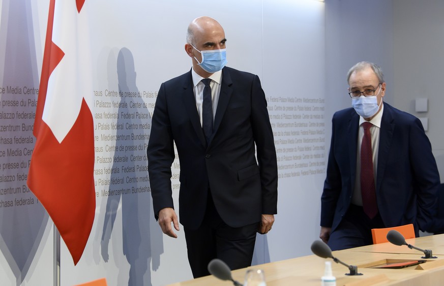 Bundespraesident Guy Parmelin, rechts, und Bundesrat Alain Berset nehmen Platz zur Medienkonferenz zu den neusten Massnahmen zur Bewaeltigung der Coronavirus-Pandemie im Anschluss an die Bundesratssit ...