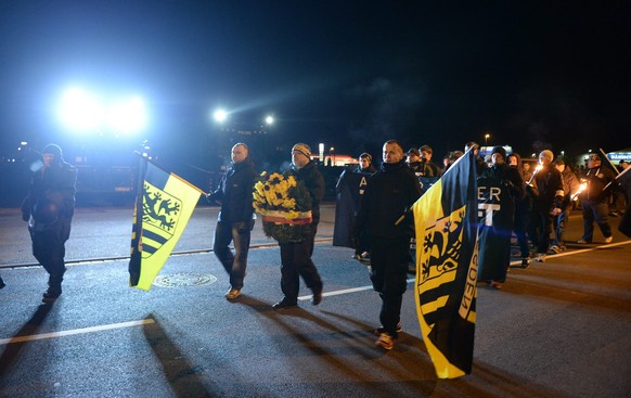 epa05157139 Members of a Neo-Nazis group march with a banner, which recalls the night of bombing of 13 February 1945, in Prohlis district of in Dresden, Germany, 12 February 2016. After a relatively s ...