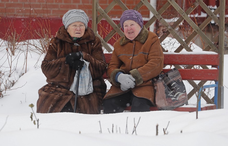 epa11067692 Russian women chat outside during snowy weather Moscow, Russia 10 January 2024. The temperatures reached about -13 degrees Celsius in the Moscow region. EPA/MAXIM SHIPENKOV