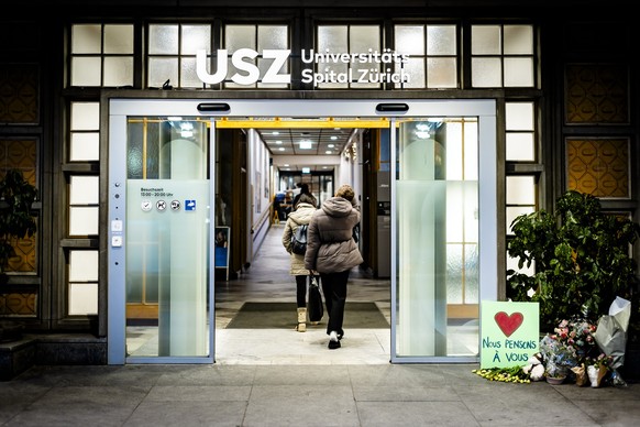Flowers and a sign with a heart and the words "We are thinking of you" are placed next to the entrance of the University Hospital Zurich (USZ) on Wednesday, January 7, 2026 in Zurich, Switze ...
