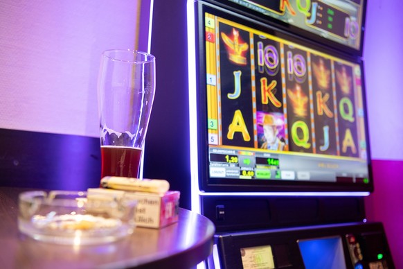 ARCHIV - 13.03.2019, Baden-W�rttemberg, Stuttgart: Ein Bier steht in einer Kneipe bei einem Spielautomat. (zu dpa: �Untersch�tzte Gl�cksspielsucht - Zocken bis in den Ruin�) Foto: Sebastian Gollnow/dp ...