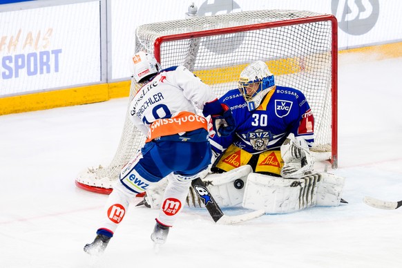 ZSC Lions&#039; Nicolas Baechler, links, scheitert an EV Zugs Torhueter Leonardo Genoni im Eishockey Qualifikationsspiel der National League zwischen dem EV Zug und den ZSC Lions am Dienstag, 28. Nove ...