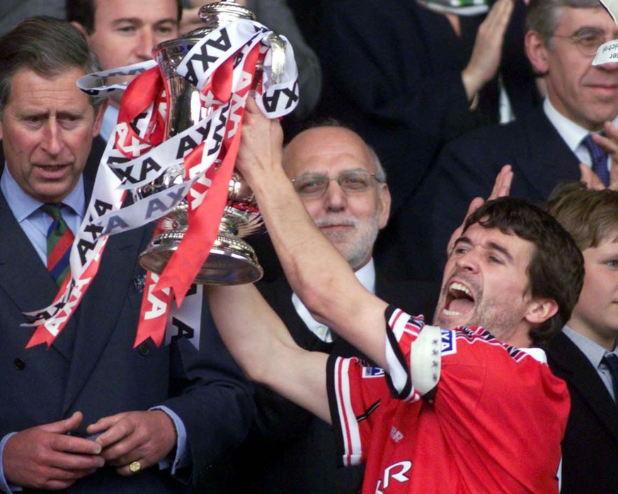 Manchester United&#039; s captain Roy Keane holds up the English Football Association Cup, after defeating Newcastle United 2-0 in the final at London&#039;s Wembley stadium, Saturday May 22, 1999. At ...