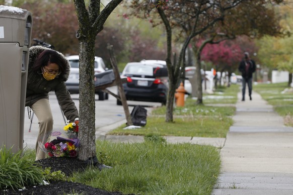 Andrea Brewer, of Columbus, places flowers on a makeshift memorial in the neighborhood where a Columbus police officer fatally shot a teenage girl Wednesday, April 21, 2021, in Columbus, Ohio. (AP Pho ...