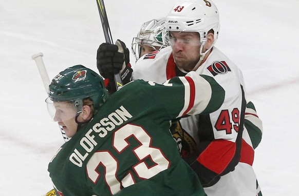 Minnesota Wild&#039;s Gustav Olofsson, left, of Sweden, wraps up Ottawa Senators&#039; Chris Didomenico in the first period of an NHL hockey game Monday, Jan. 22, 2018, in St. Paul, Minn. (AP Photo/Ji ...