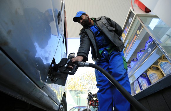 epa08913925 A gas station attendant fills a car in Peshawar, Pakistan, 01 January 2021. The Pakistani government on 01 January increased fuel prices, raising the petrol price to Rs 106.50 (0.66 US dol ...