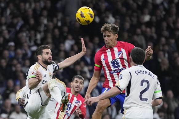 Atletico Madrid&#039;s Marcos Llorente, top right, scores his side&#039;s first goal during the Spanish La Liga soccer match between Real Madrid and Atletico Madrid at the Santiago Bernabeu stadium in ...