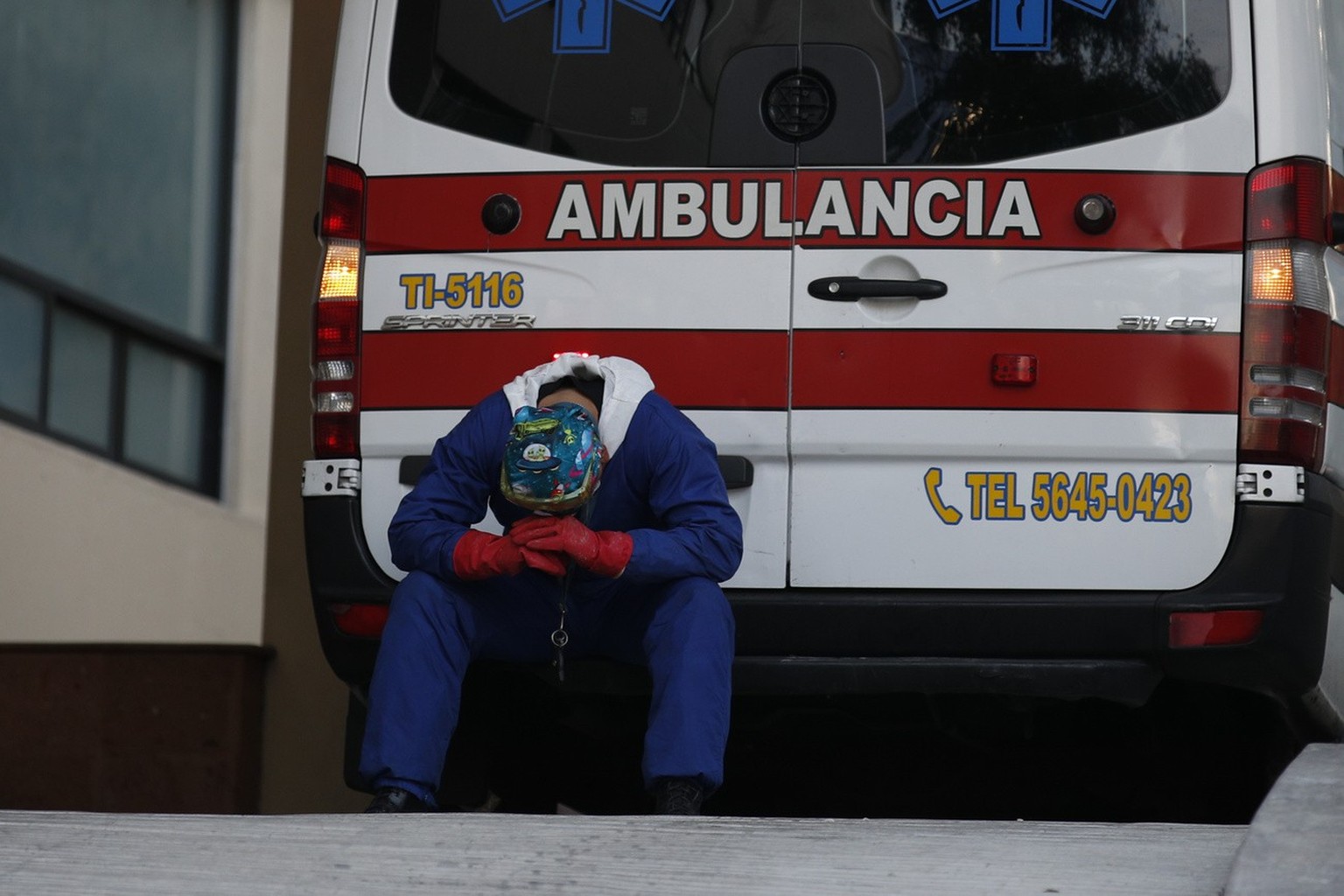 A paramedic rests behind his ambulance, as ambulance staff wait hours for the COVID-19 patients they are transporting to be admitted, at Siglo XXI Medical Center in Mexico City, Thursday, Jan. 7, 2021 ...
