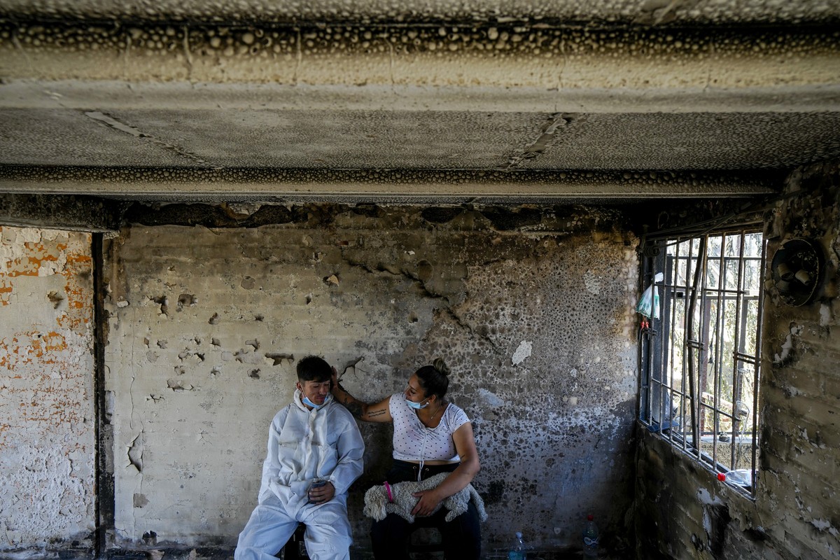 Camila Lange, who is 7-months-pregnant, and her husband Felipe Corvalan sit with their dog Florencia inside their home that was burned by a deadly wildfire in Vina del Mar, Chile, Monday, Feb. 5, 2024 ...