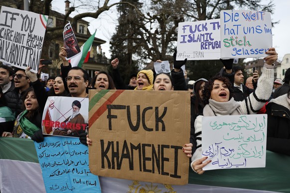 epa12655587 Protesters shout slogans and hold placards during a protest against the Iranian regime in front of the Iranian embassy in Bern, Switzerland, 17 January 2026. An economic crisis and politic ...