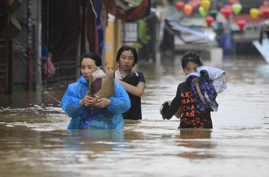 People wade through flooded street of Hoi An ancient town, Vietnam, Monday, Nov. 6, 2017. Typhoon Damrey has killed dozens of people, and left more than a dozen missing and caused extensive damage to  ...