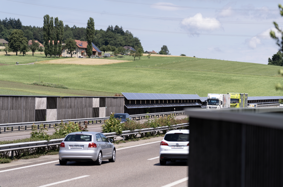 Laermschutzwaende aus Holz schuetzen die Bewohner der nahgelegenen Haeuser vor dem Laerm der Autobahn A1, fotografiert am 24. Juni 2021 in Safenwil, Kanton Aargau. Teile der Laermschutzwand bestehen a ...